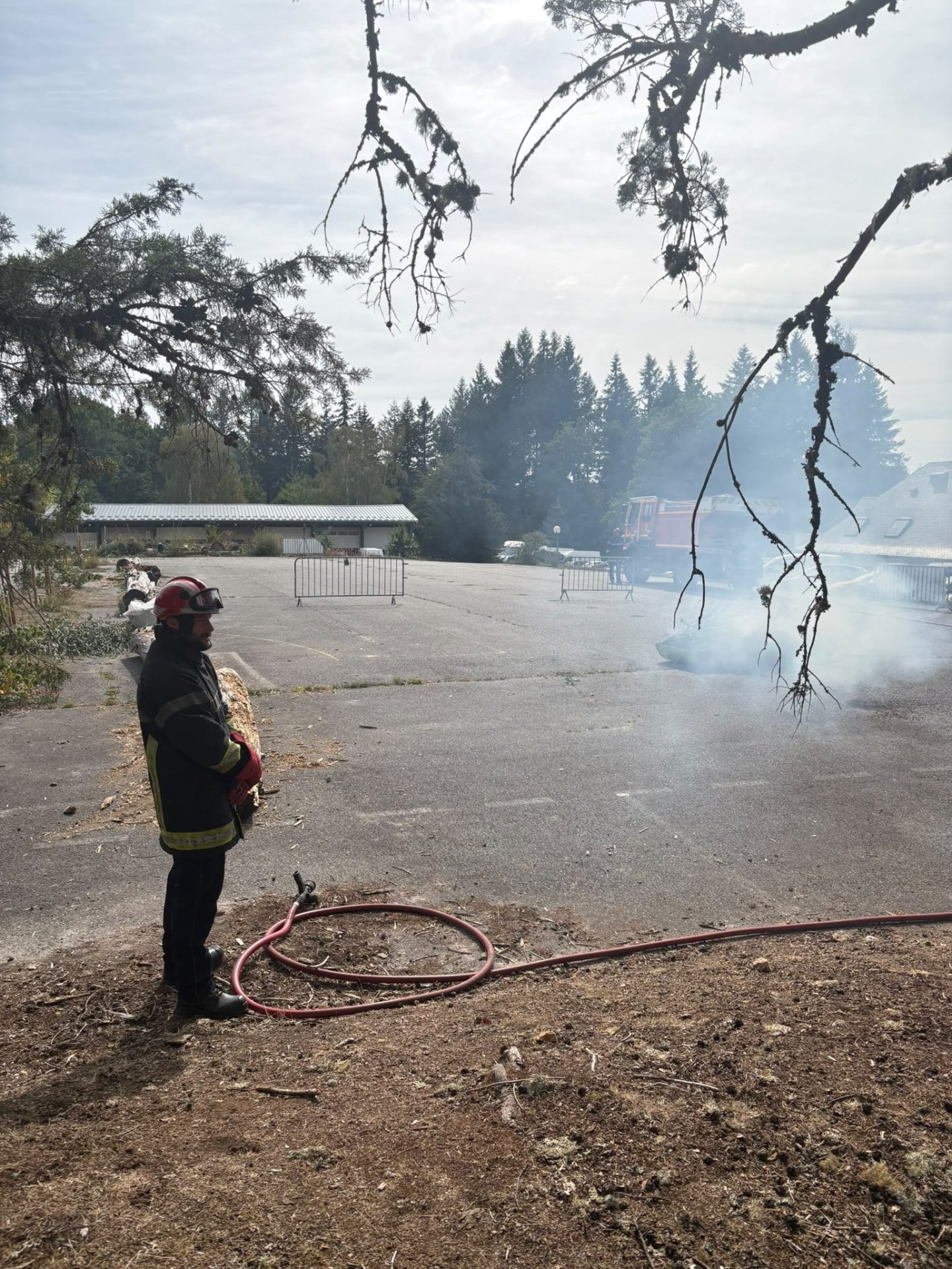 Un bombero observa una fuente de humo controlada durante la prueba en directo en el banco de pruebas de Meymac (Francia)